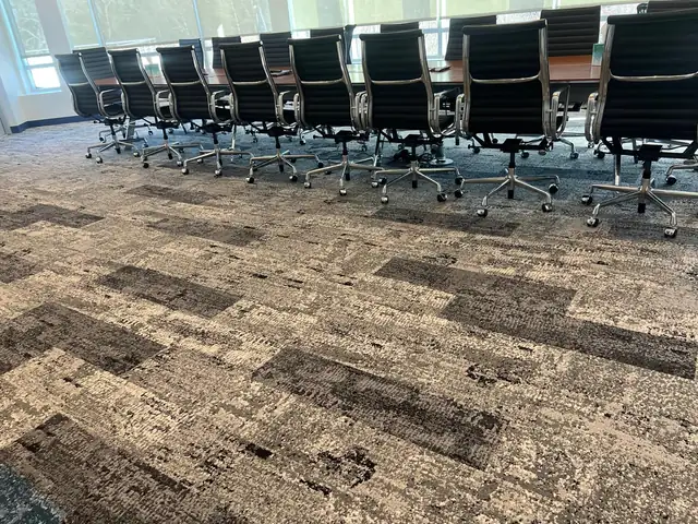 Patterned carpet underneath a conference table and chairs